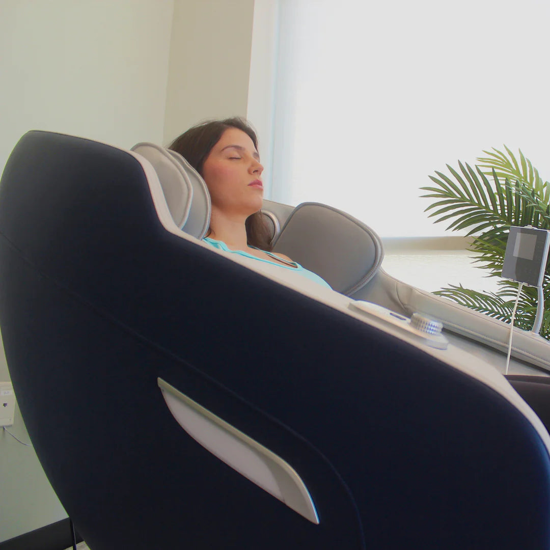 Woman relaxing in a massage chair with a plant and window in the background