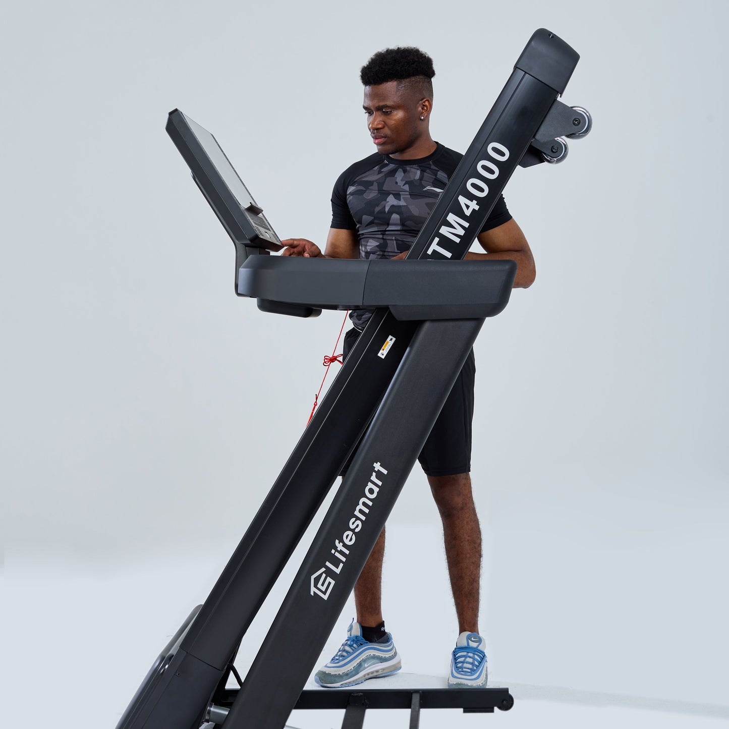 Healthy and active man folding TM4000 treadmill with PowerTouch technology