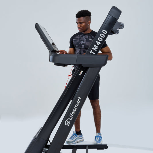 Healthy and active man folding TM4000 treadmill with PowerTouch technology