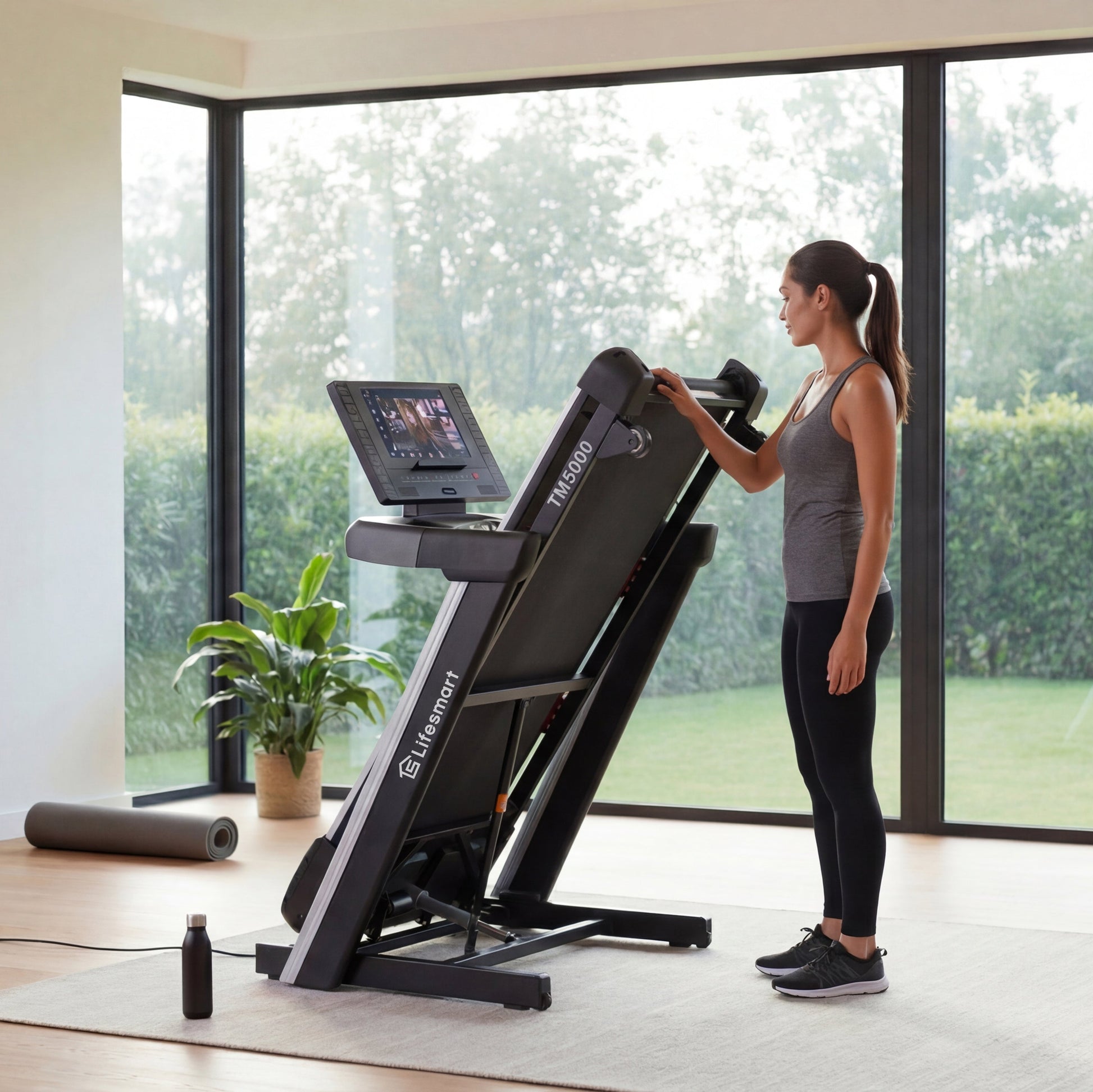 Woman using a Lifesmart TM5000 treadmill in a modern home gym with large windows.